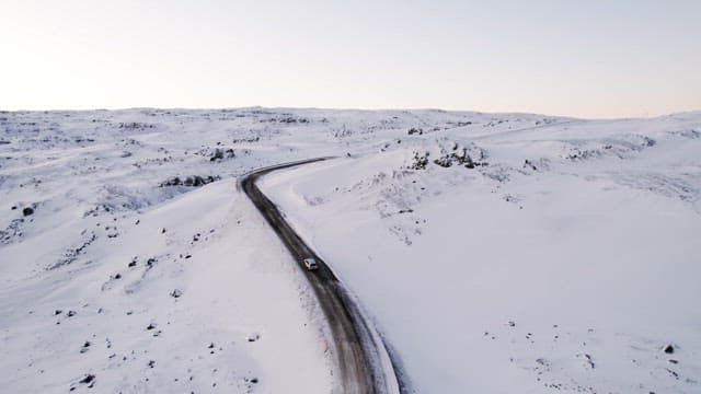 Car driving through a snowy landscape