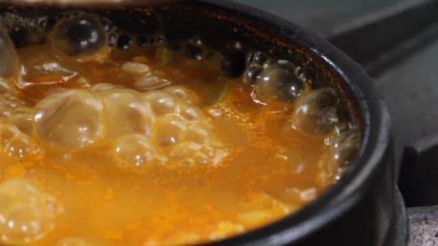 Cooking Stew with Fresh Greens in a Pot on the Stove