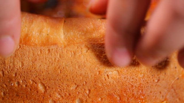 Tearing the dough of a freshly baked pizza