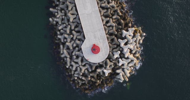 Lighthouse on a breakwater surrounded by the sea