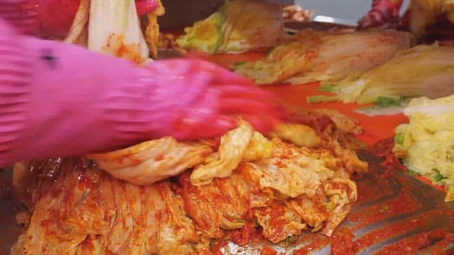 Making kimchi by adding chili pepper seasoning to cabbage
