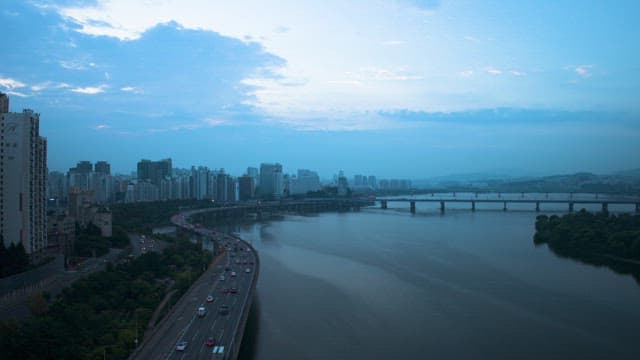 Dusk View Over Urban River and Traffic