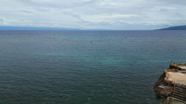Small boat on a vast ocean