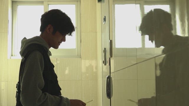 Man attaching flyers on front door in dark hallway