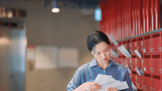 Woman checking mail in a building lobby