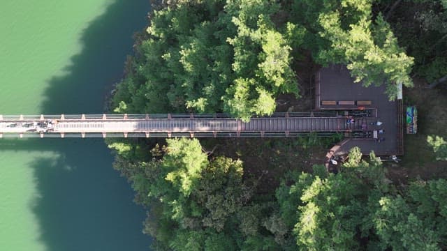 View of a Suspension Bridge with Scenic Lake and Forests