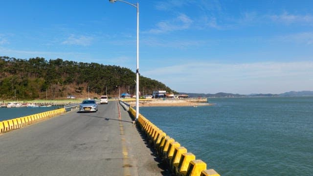 Coastal road with cars passing by and scenic views of the sea