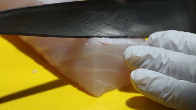 Process of filleting a fresh fish with a knife on a cutting board