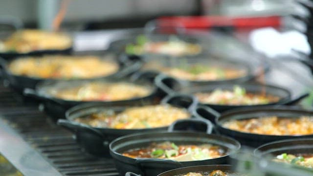 Mustard leaf kimchi stew boiling in a restaurant kitchen