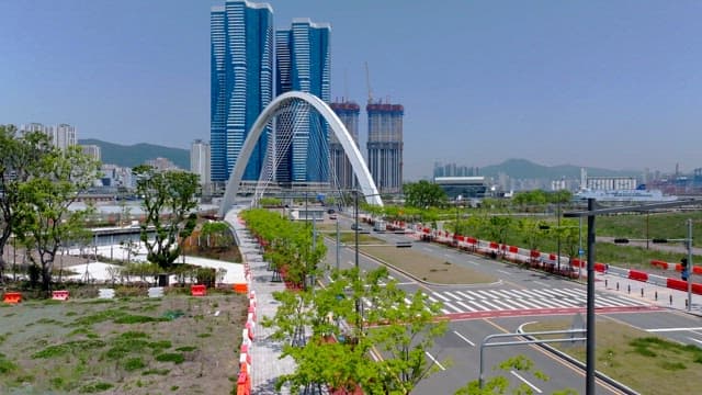 Modern urban arch architecture with skyscrapers in the background on a clear day
