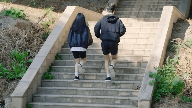 Two people jogging up outdoor stairs