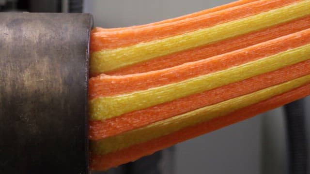 Colorful Jjondeugi Pulled Out of a Factory Machine