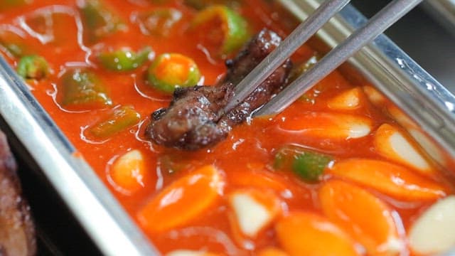 Delicious piece of grilled pork dipped in seasoning sauce