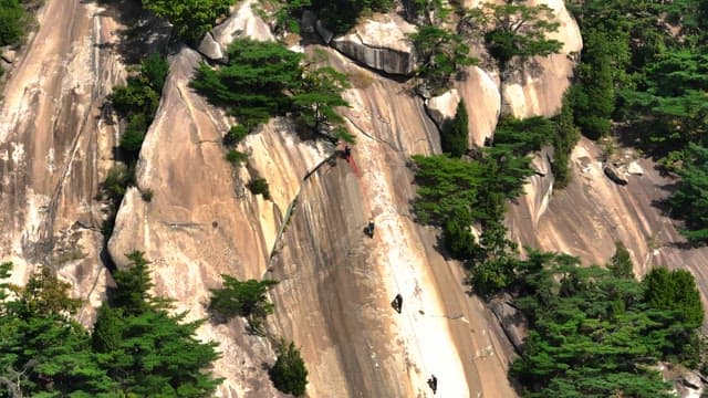 Climbers ascending a steep rocky mountain