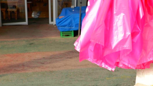 Pink plastic bag swaying in the wind in front of a store