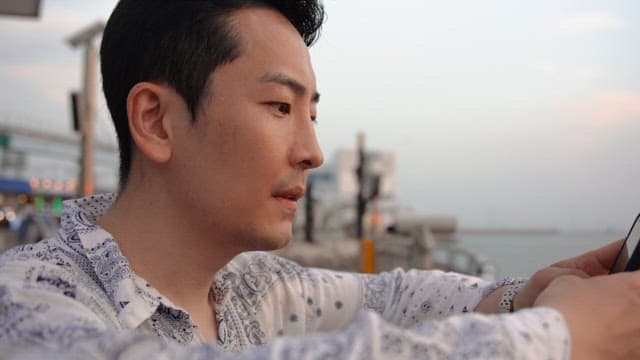 Man using a smartphone by the sea