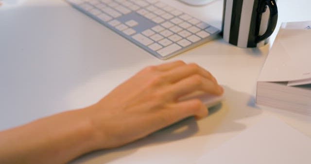Hand Using Wireless Mouse on White Desk