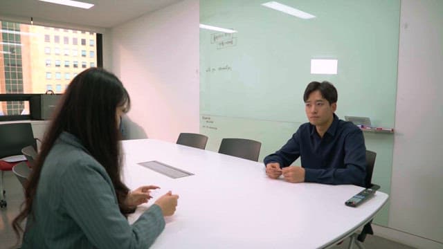 Two people exchanging business cards in an office