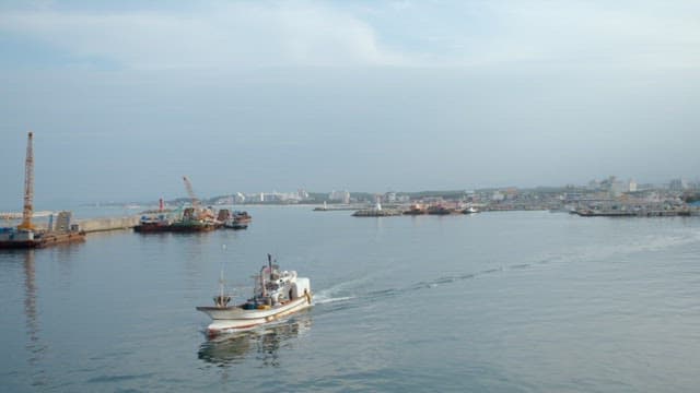 Fishing boat sailing near coastal town
