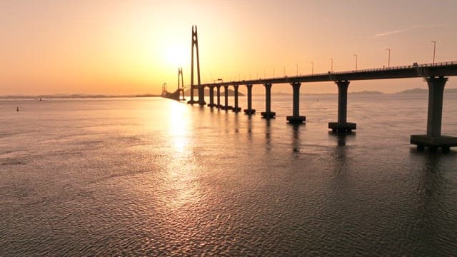 Bridge over calm waters at sunset