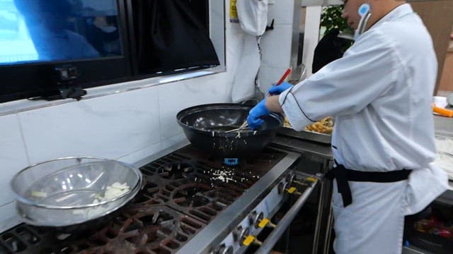 Chef deep frying webfoot octopus in hot oil