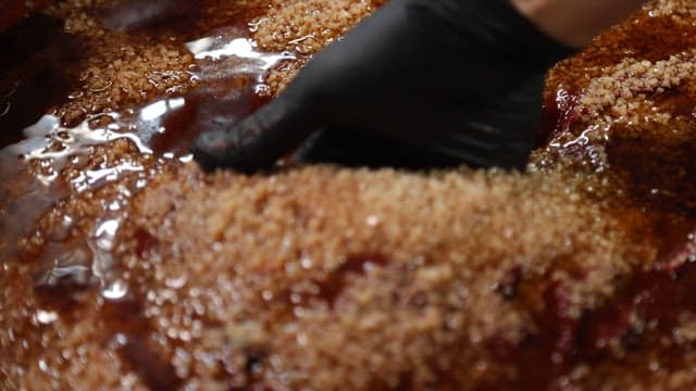 Mixing red, thick gochujang with gloved hands