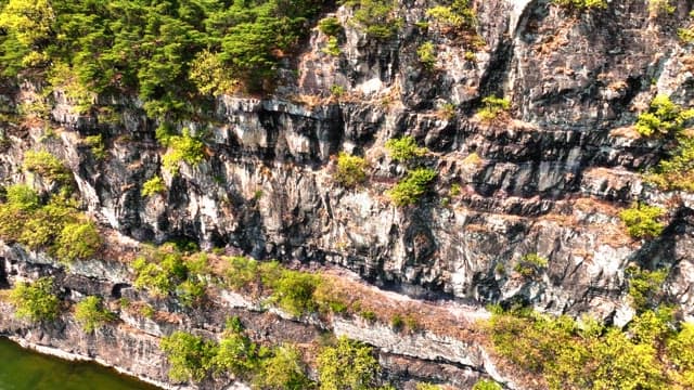 Tranquil river flowing alongside rocky cliffs