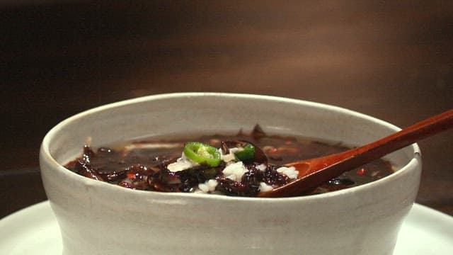 Refreshing chilled seaweed soup in a bowl with a wooden spoon