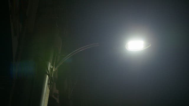 Bright Streetlight Illuminating a Dark Alley at Night