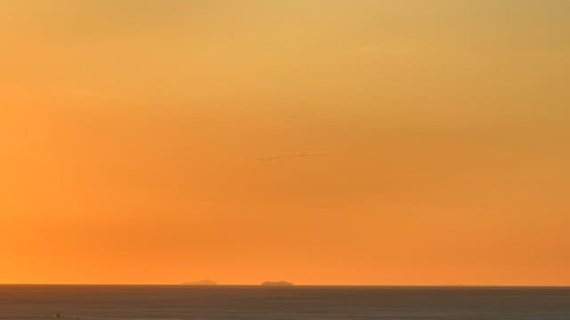 Sunset over the ocean with distant islands