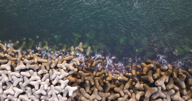 Waves crashing against concrete barriers