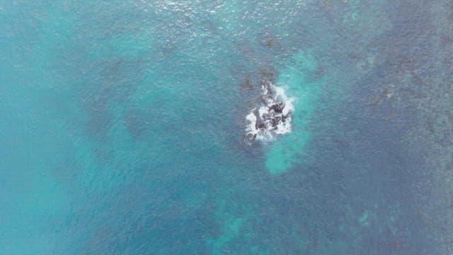 Waves gently crashing against rocks in the sea