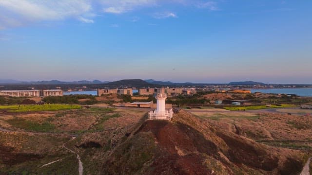 Lighthouse on a coastal cliff at sunset