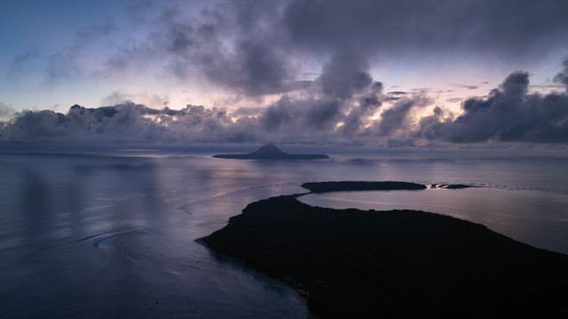 Island at dawn with clouds and ocean