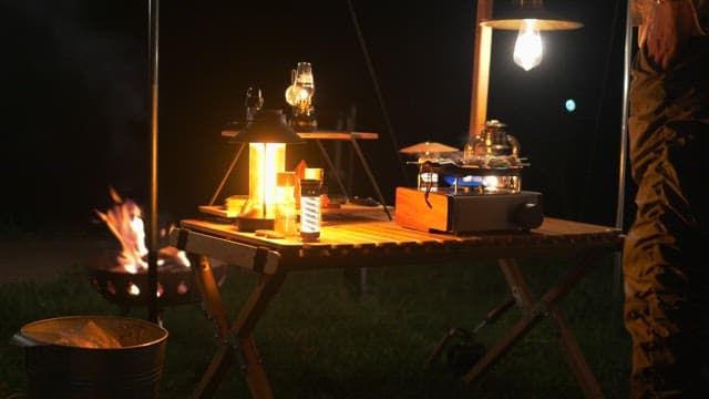 Camping with portable stove and campfire at night