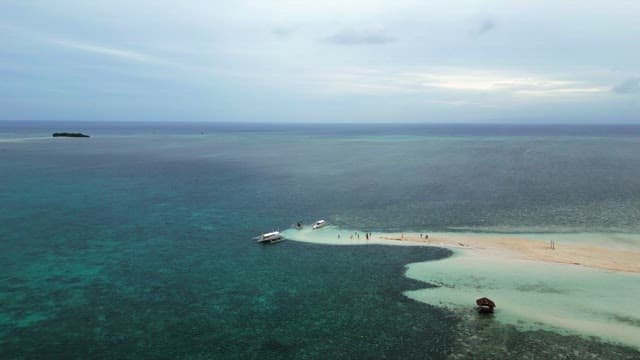 Small sand beach with boats and people