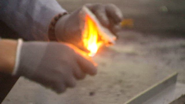 Worker testing fire resistance of insulation material