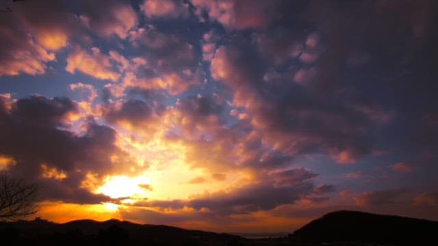 Sunset with vibrant clouds over mountains