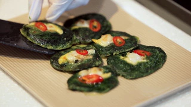 Plate of green vegetable pancakes neatly arranged on a plate