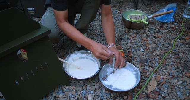 Preparing a meal outdoors with simple utensils