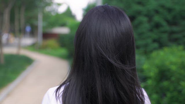 Woman looking up while walking down the street