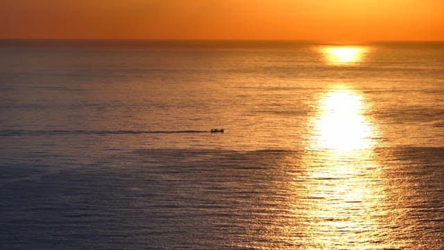Small boat on the ocean at sunset