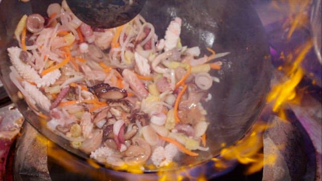 Stir-frying in a flaming wok at high heat