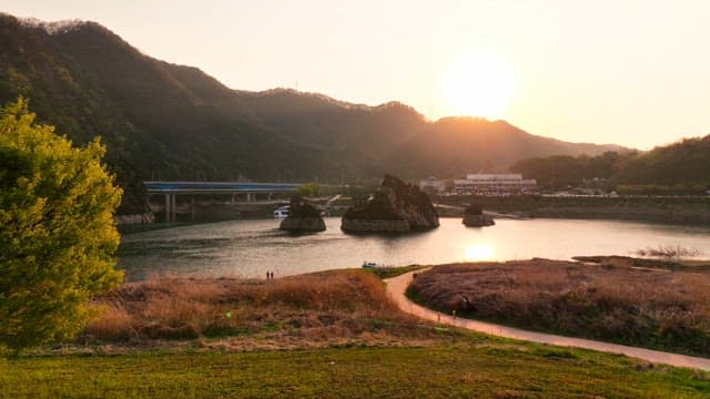 Sunset over a serene river with mountains