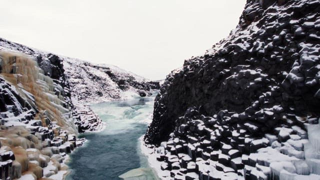 Snow-covered canyon with icy river