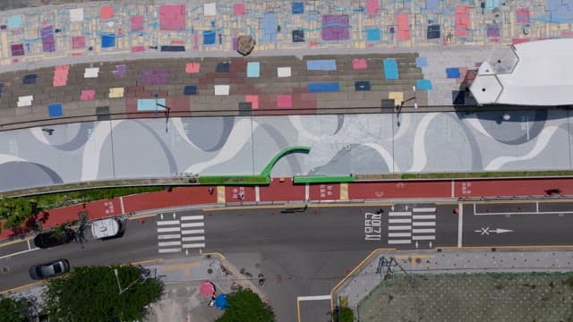 View of sidewalk with colorful paintings and a quiet road