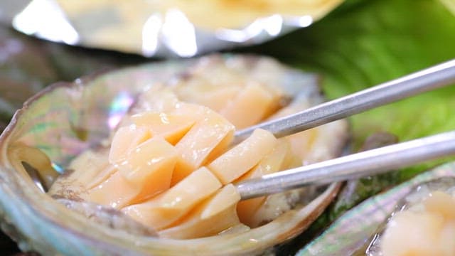 Chopstickful of fresh abalone sashimi