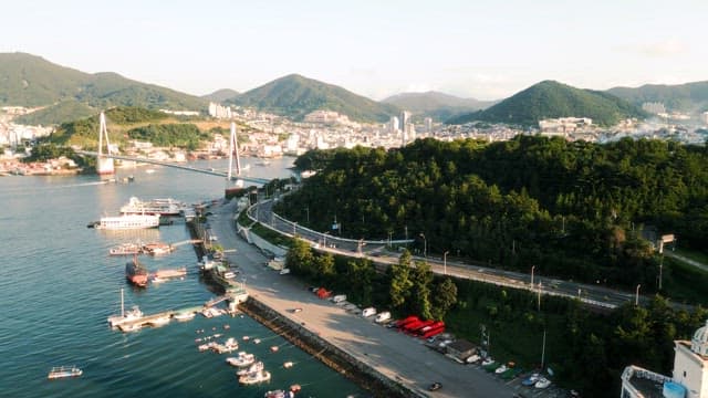 Coastal City with Bridge and Boats at Sunset