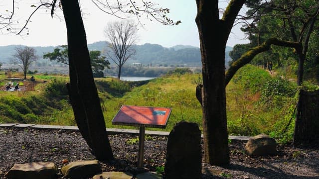 People working and riding bicycles in a landscape with mountains in the distance
