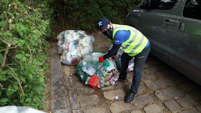 Workers managing and sorting recycled waste near a truck